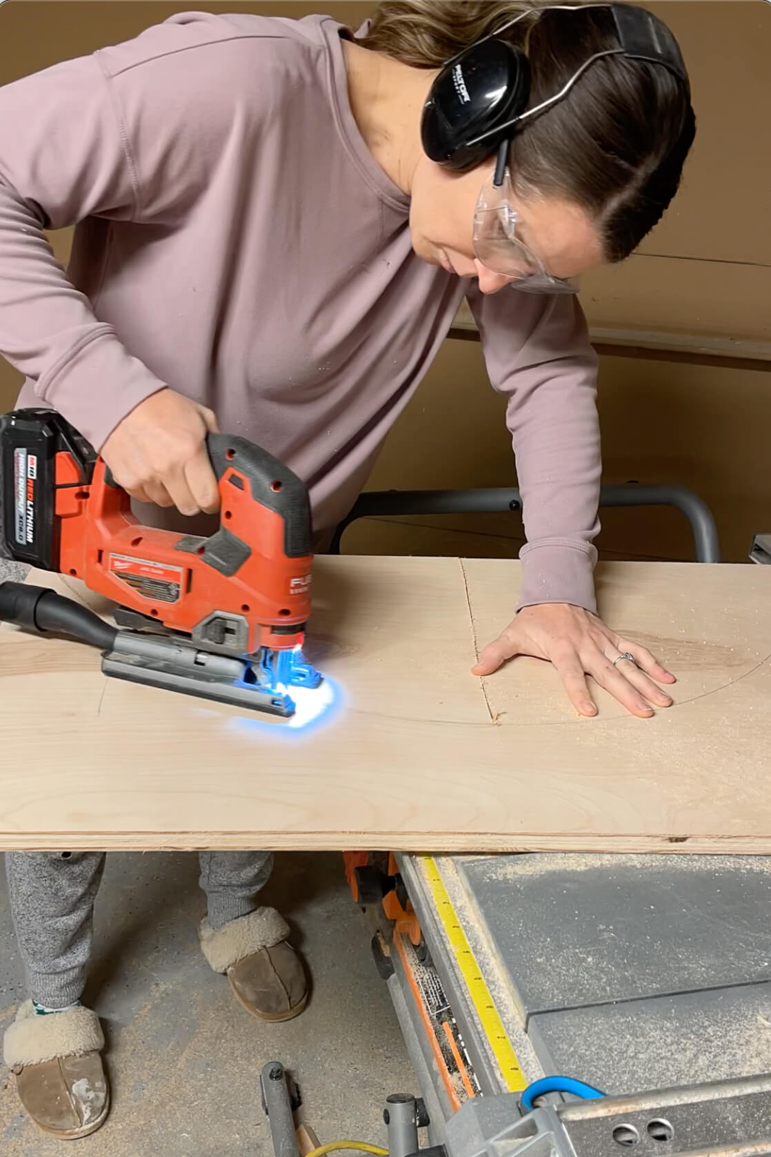 Using a jig saw to cut out an arch for the top of a shelf.